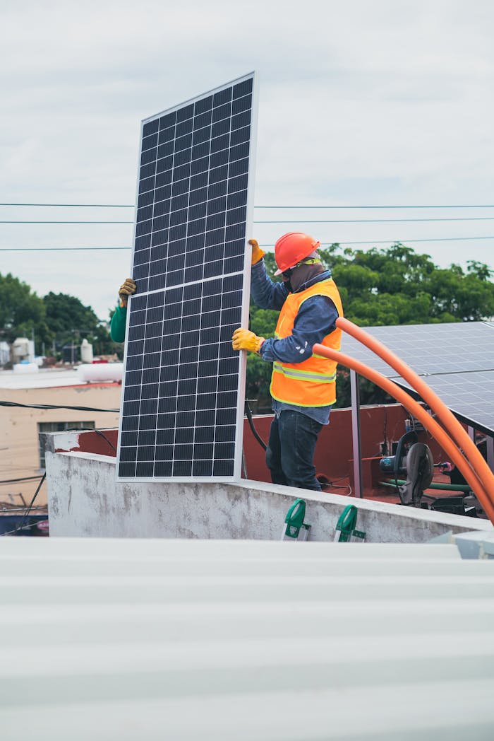 Home A technician in safety gear installs a solar panel on a rooftop, promoting renewable energy.